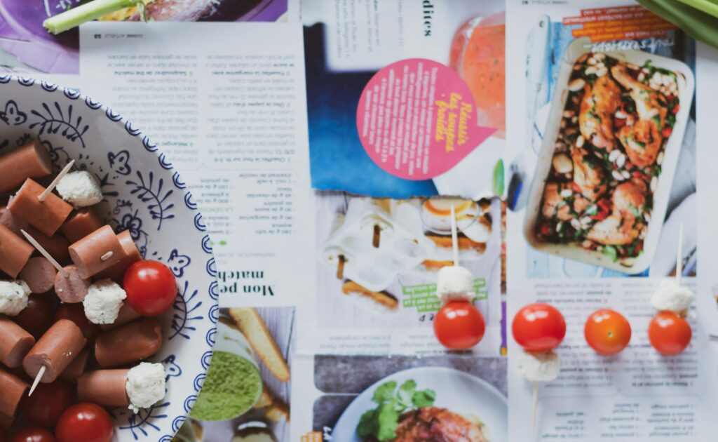Tasty snack skewers with cherry tomatoes and cheese on a cookbook background.